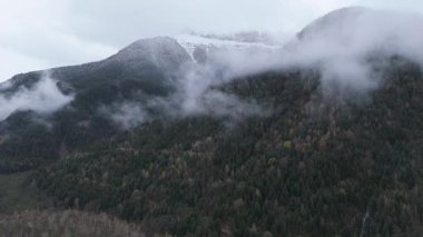 Hava aracı videosu bulutlu bir havada görkemli dağları yakalıyor.