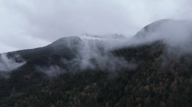 Dağlarda bulutlu hava. İnsansız hava aracı videosu tepelerle görkemli manzarayı yakalıyor