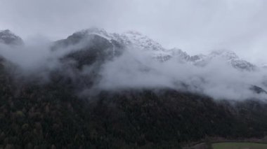 Dağlarda bulutlu hava. İnsansız hava aracı videosu tepelerle görkemli manzarayı yakalıyor