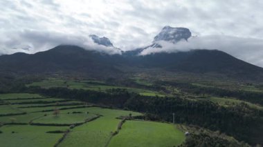 Yavaş uçan dron görkemli dağları ve bulutlu gökyüzünü kaydediyor. 