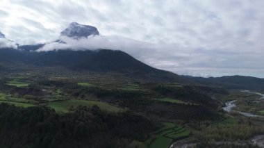 Yavaş uçan dron görkemli dağları ve bulutlu gökyüzünü kaydediyor. 