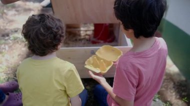 Tavuklu tavuk kümesinden yavaş çekim videosu. Çocuklar yumurta topluyor. 