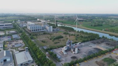 Endüstriyel fabrikaları ve rüzgar türbinleri olan bir şehrin yavaş çekim görüntüleri..