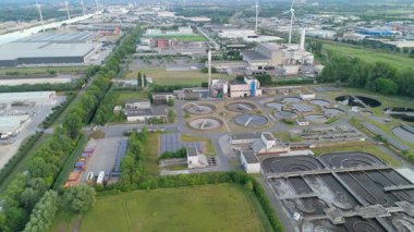 Endüstriyel fabrikaları ve rüzgar türbinleri olan bir şehrin yavaş çekim görüntüleri..