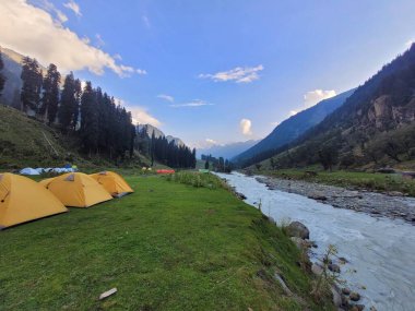 Dağları ve mavi gökyüzü olan güzel bir manzara.