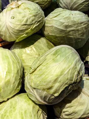  Yeşil lahana yığını, sert yapraklarını sergiliyor ve çekici dokularını sergiliyor. Yemek pişirme, sağlıklı beslenme ve tarımla ilgili projeler için ideal görüntü.