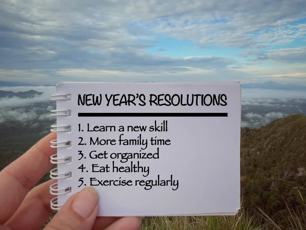 Yeni yıl motivasyon konsepti. Not defterine yazılmış yeni yıl kararları ve listeleri. Bulanık stil arkaplanlı.