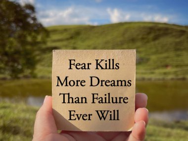 Motivational and inspirational wording. Fear Kills More Dreams Than Failure Ever Will written on a notepad. With blurred styled background. clipart