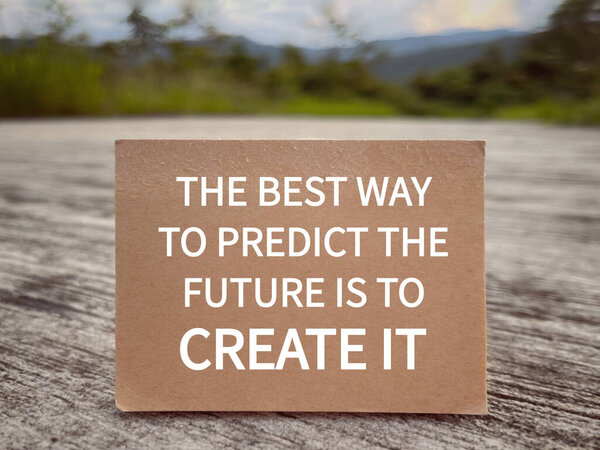 Motivational and inspirational wording. The Best Way To Predict The Future Is To Create It written on a notepad. With blurred styled background.