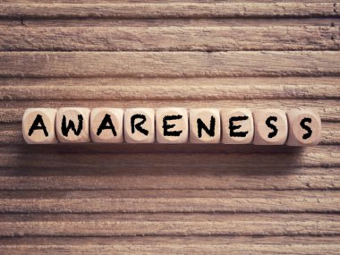 Awareness and Educational concept. AWARENESS written on wooden blocks. On blurred styled background. clipart