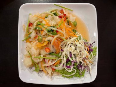 Yemek ve mutfak konsepti. Tayland yemeği menüsü. Tatlı, ekşi ve baharatlı kemiksiz tavuk ayağı ve salata..