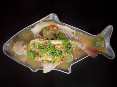 Yemek ve mutfak konsepti. Tayland yemeği menüsü. Buharlı kireç balığı masada servis edilir..