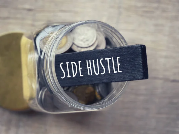 Self income and economic stability concept. SIDE HUSTLE written on a wooden block. With blurred styled background.