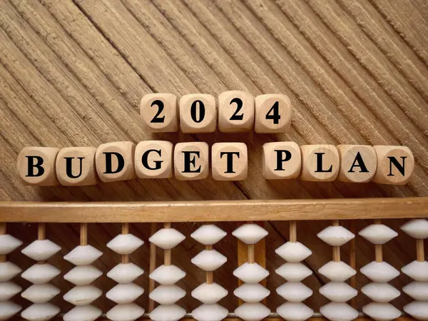 Yeni yıl finansal planı konsepti. 2024 Bütçe Planı ahşap bloklara yazılmış. Bulanık stil arkaplanlı.