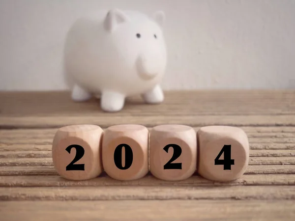 Yeni yıl finansal planı konsepti. 2024 ahşap bloklara yazılmış. Bulanık stil arkaplanlı.