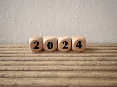Yeni yıl finansal planı konsepti. 2024 ahşap bloklara yazılmış. Bulanık stil arkaplanlı.