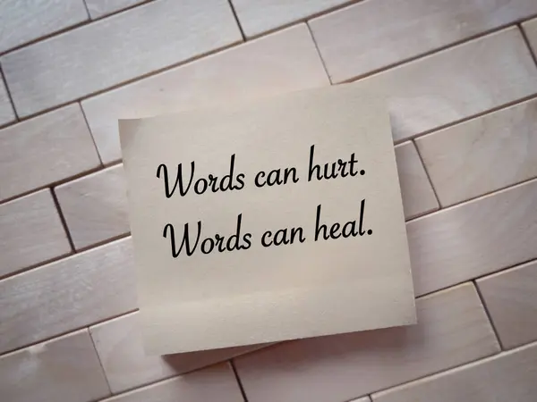 Motivational and inspirational wording. Words can hurt, Words can heal written on a notepad. With blurred style background.