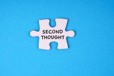 Motive edici ve ilham verici bir kelime. Bir yapboz parçasına yazılmış ikinci bir düşünce. Mavi arkaplanda.