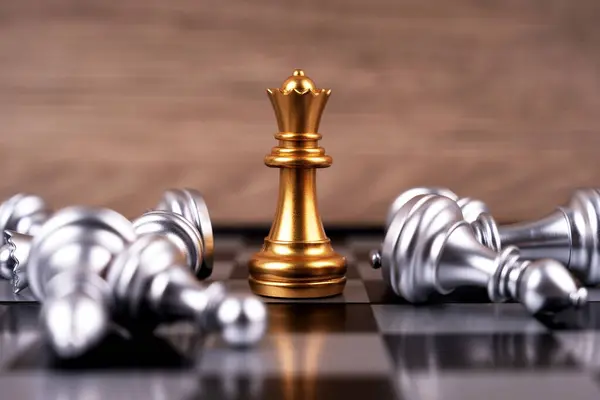 Motivational business and management concept. Golden chess pieces placed on a chessboard. Blurred styled background.