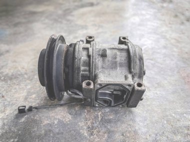 Ulaşım ve teknoloji konsepti. Paslı ve bozuk araçların havalandırma kompresörü yere yerleştirilmiş..