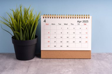 Monthly calendar for April 2025 on a table.
