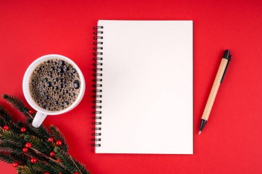 Noel süslemeleri ve kırmızı arka planda fotokopi alanı için boş defter. Noel konsepti.