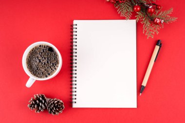 Noel süslemeleri ve kırmızı arka planda fotokopi alanı için boş defter. Noel konsepti.