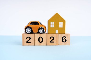 2026, ahşap bloklarda küçük araba ve ev modeliyle yazılmış. Yeni yıl planı konsepti