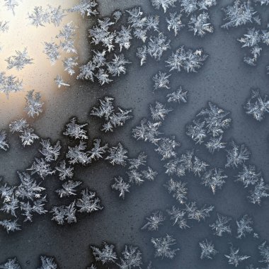 Finlandiya 'da Noel zamanı soğuk bir kış gününde donmuş bir camın yüzeyindeki buz kristalleri. Güzel bir tatil sezonu yakın çekim dokusu resmi. Gündüz fotoğrafı.