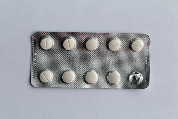 No logo white tablets. Different pills can be used in healthcare to treat different diseases and symptoms like allergies, infections and pain. Closeup color image.