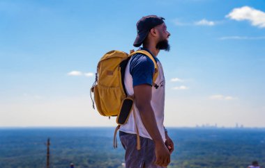 Ormandaki bir tepede sırt çantalı bir yürüyüşçü.