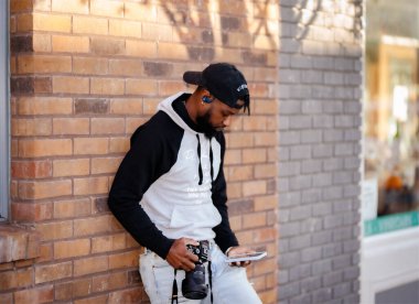 Adam telefonuna bakarken duvara asılmış.