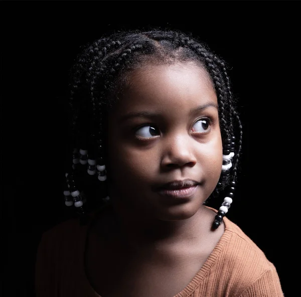 portrait of black american little girl model with a black background