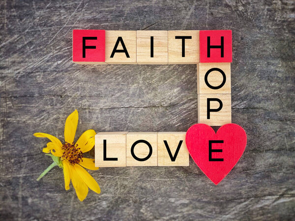Faith hope love text on wooden blocks with vintage background.