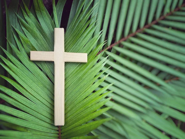 Lent Season,Holy Week and Good Friday Concepts - Wooden cross on palm leaves with vintage background.