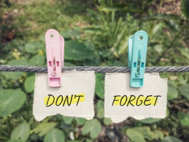 Çamaşır ipinde raptiyelerle kağıda yazılmış metni unutma..