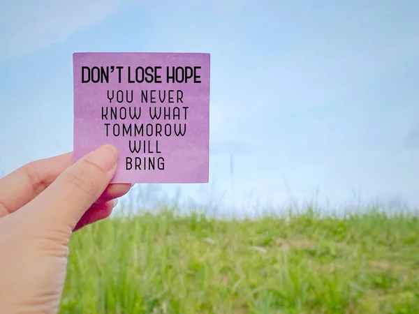 Motivational Inspirational Quote Concept - Don\'t lose hope you never know what tomorrow will bring text on paper with nature background.