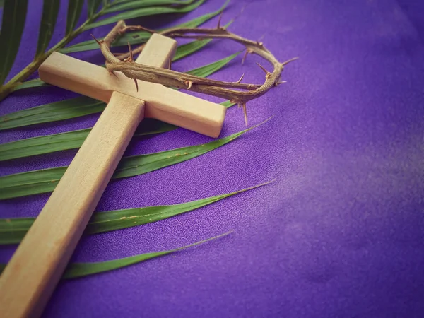 Kutsal Hafta, Paskalya Perhizi, Kutsal Cuma, Paskalya Pazarı Konsepti. Dikenli taç, ahşap haç ve mor arka planı olan palmiye yaprağı..