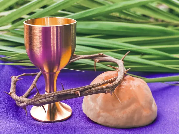 Holy Week, Lent, Palm Sunday, Maundy Thursday, Good Friday, Easter Sunday Concept. Chalice, Crown of thorns, bread and palm leaf with purple background.