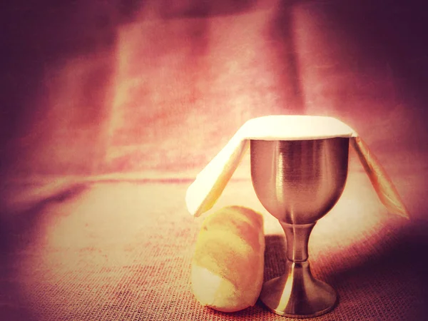 Lent Season, Holy Week and Maundy Thursday Concept - with chalice and bread in red colour background.