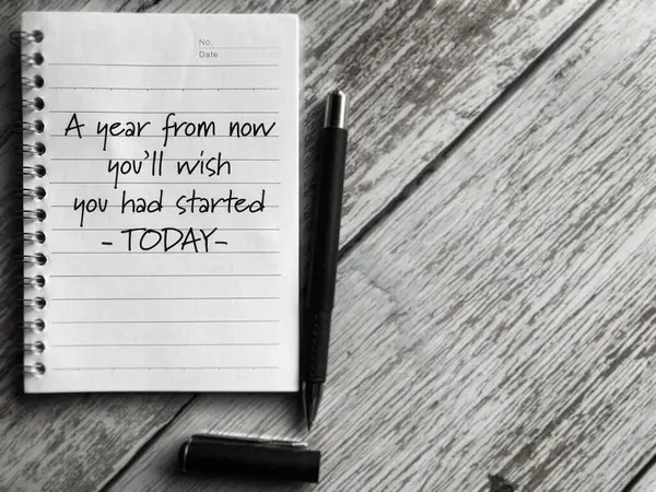Bir yıl sonra, bugün başlamış olmayı dileyeceksin. Kitap arkaplanına yazılmış bir mesaj. Stok fotoğrafı.