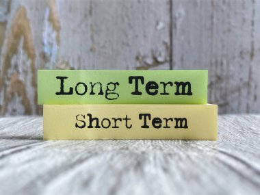 Yapışkan not kağıdıyla ilgili uzun vadeli kısa vadeli metin. Stok fotoğrafı.