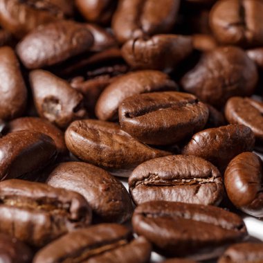 Taze kavrulmuş kahve çekirdekleri. Ahşap arka planda kepçeyle kavrulmuş kahve çekirdekleri..