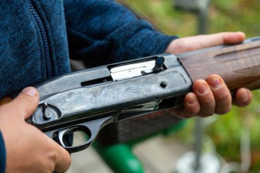 Skeet Atıcılık. Güneşli bir günde atış poligonunda atış talimi yapan bir adam. Tek başına, kendinden emin, yetenekli ve deneyimli. Atış ve Silahlar.