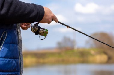 Balıkçı oltası balıkçıları yaz sporu yapar. Gölde oltayla balık tutan balıkçı. Balık tutmaya. Balıkçı ve alabalık. Fly Fishings zamanı. Göl kıyısında elinde olta olan balıkçı..