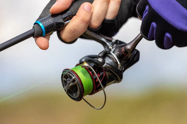 Silver fishing bells are worn on a fishing rod while fishing. Bite-call  signal, at the tip of the rod. A bite alarm will alert you to a bite.  Fishing tackle close-up. 11365671