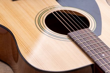 Klasik gitar, yakın çekim. Ahşap arka planda akustik gitar. Müzik aleti konsepti.