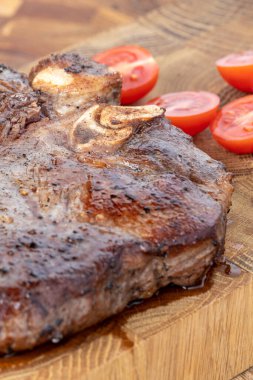 Kesme tahtasındaki biftek, otlar ve baharatlarla. Ahşap tahtada ızgara sebzelerle ızgara sığır filetosu. Filet Mignon tarif konsepti, seçici odaklanma