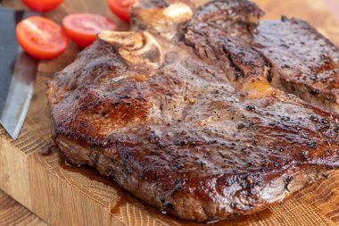 Kesme tahtasındaki biftek, otlar ve baharatlarla. Ahşap tahtada ızgara sebzelerle ızgara sığır filetosu. Filet Mignon tarif konsepti, seçici odaklanma