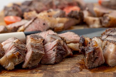 Kesme tahtasındaki biftek, otlar ve baharatlarla. Ahşap tahtada ızgara sebzelerle ızgara sığır filetosu. Filet Mignon tarif konsepti, seçici odaklanma